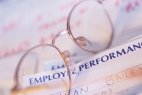 Eyeglasses on top of paper headed Employee Performance